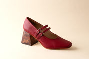 Red shoe with a wooden heel on a beige background