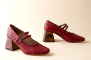 Pair of red shoes with wooden heels on a beige background