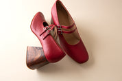 Red shoes with a wooden heel on a beige background