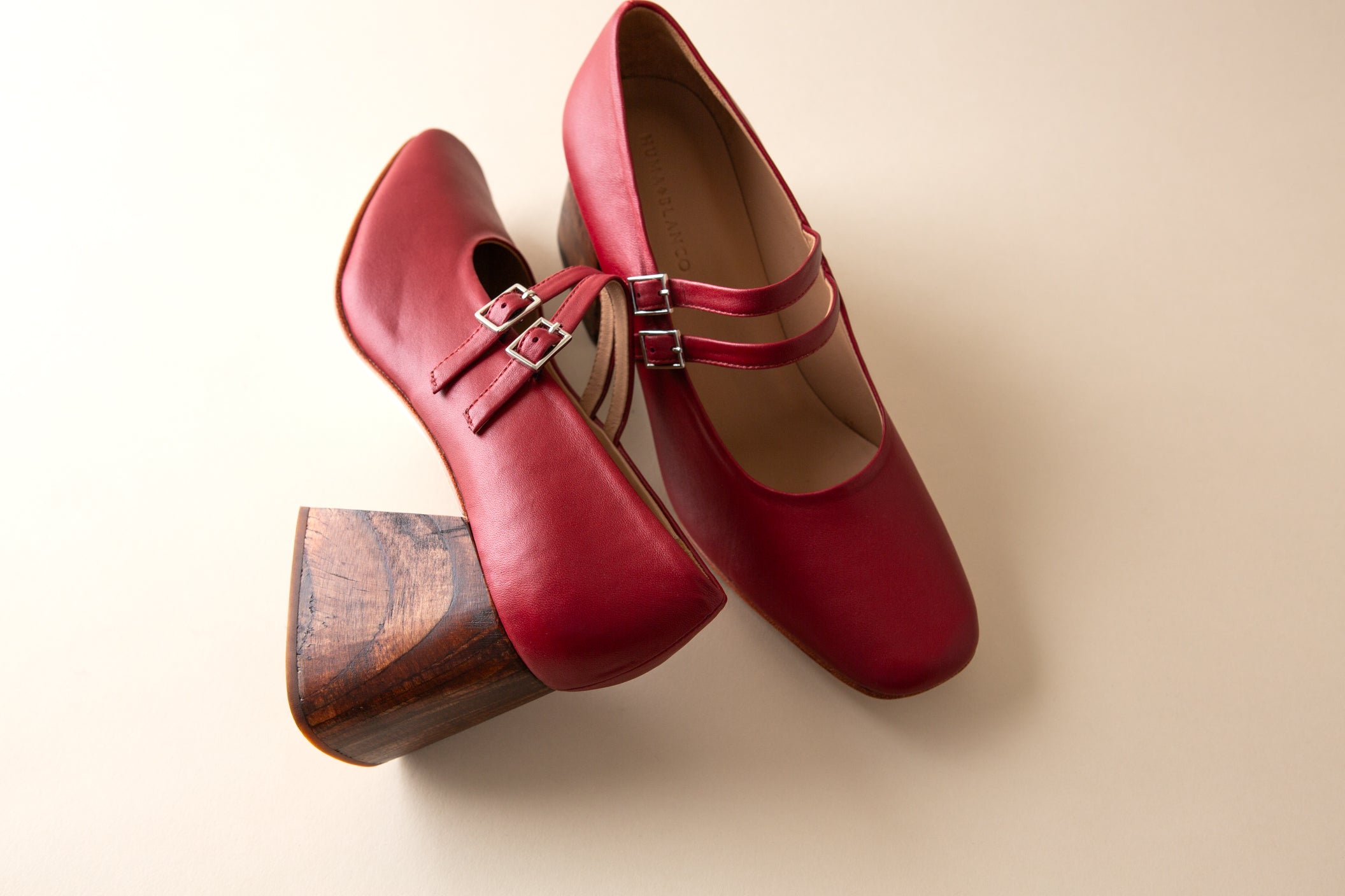 Red shoes with a wooden heel on a beige background