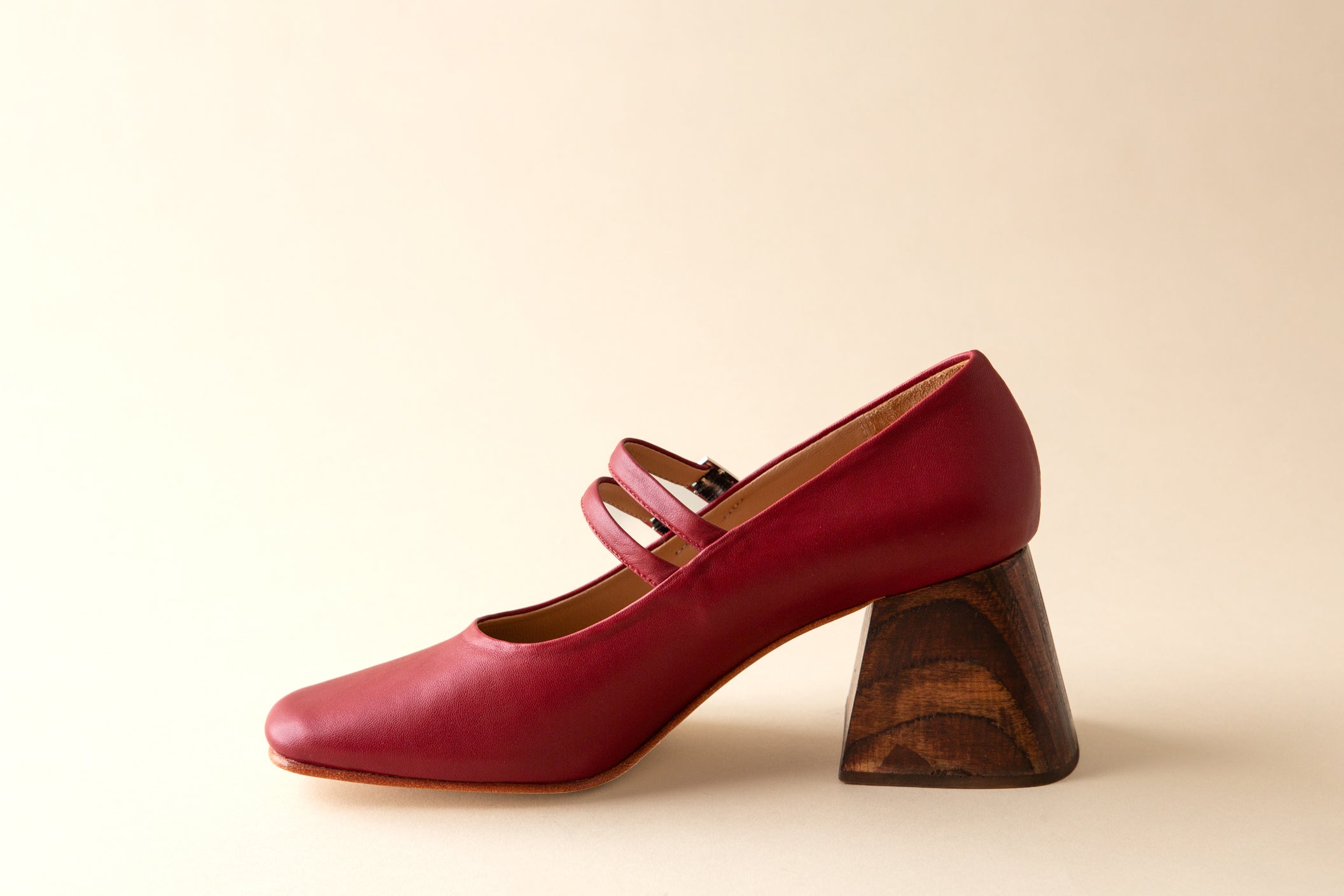 Red shoe with a wooden heel on a beige background