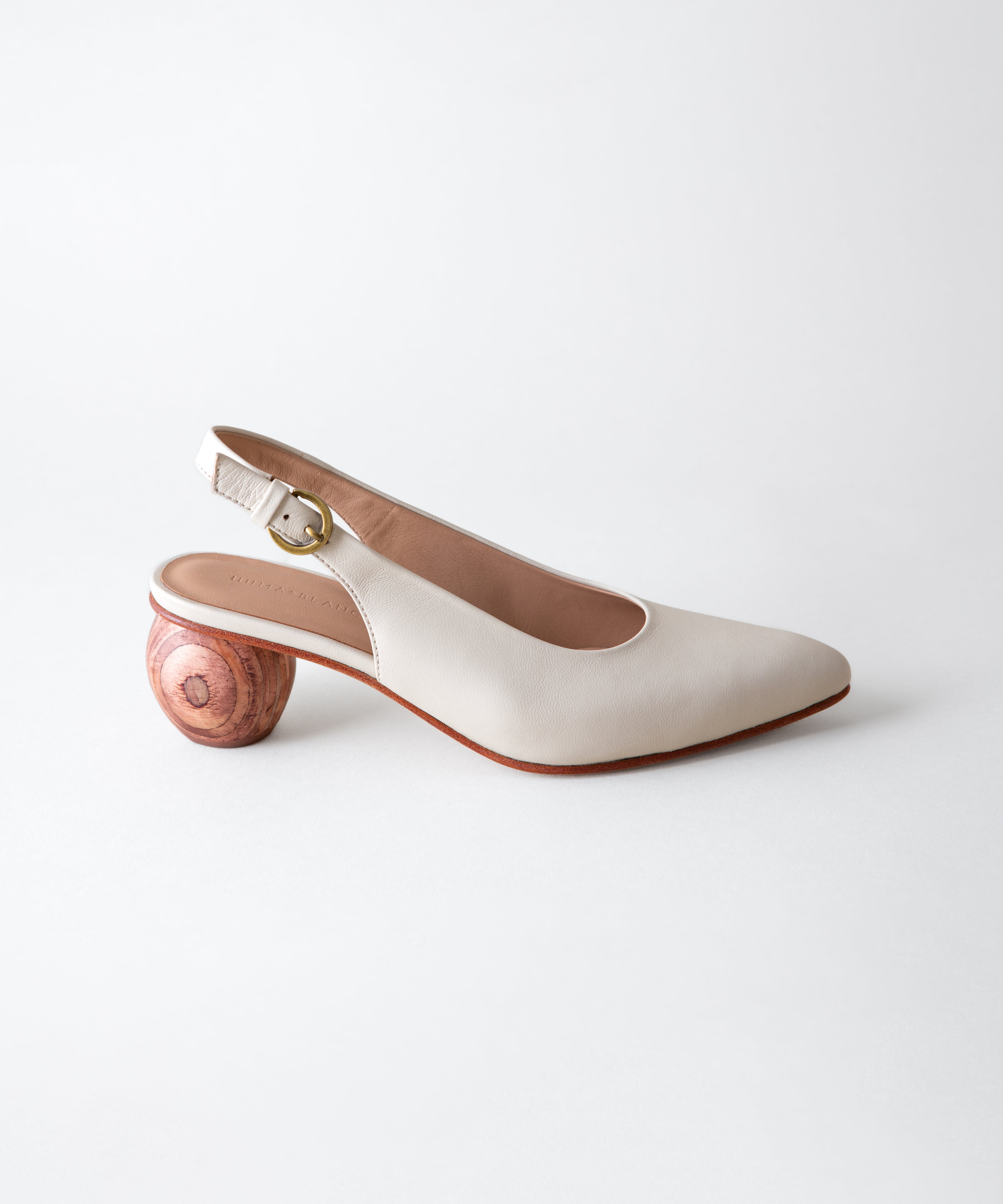 White shoe with wooden heel on a light gray background