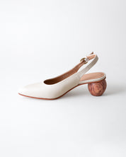 White shoe with wooden heel on a light gray background