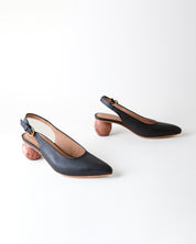 Black high-heeled shoes with slingback design on a white background