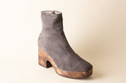 Gray suede ankle boot with wooden sole on a beige background
