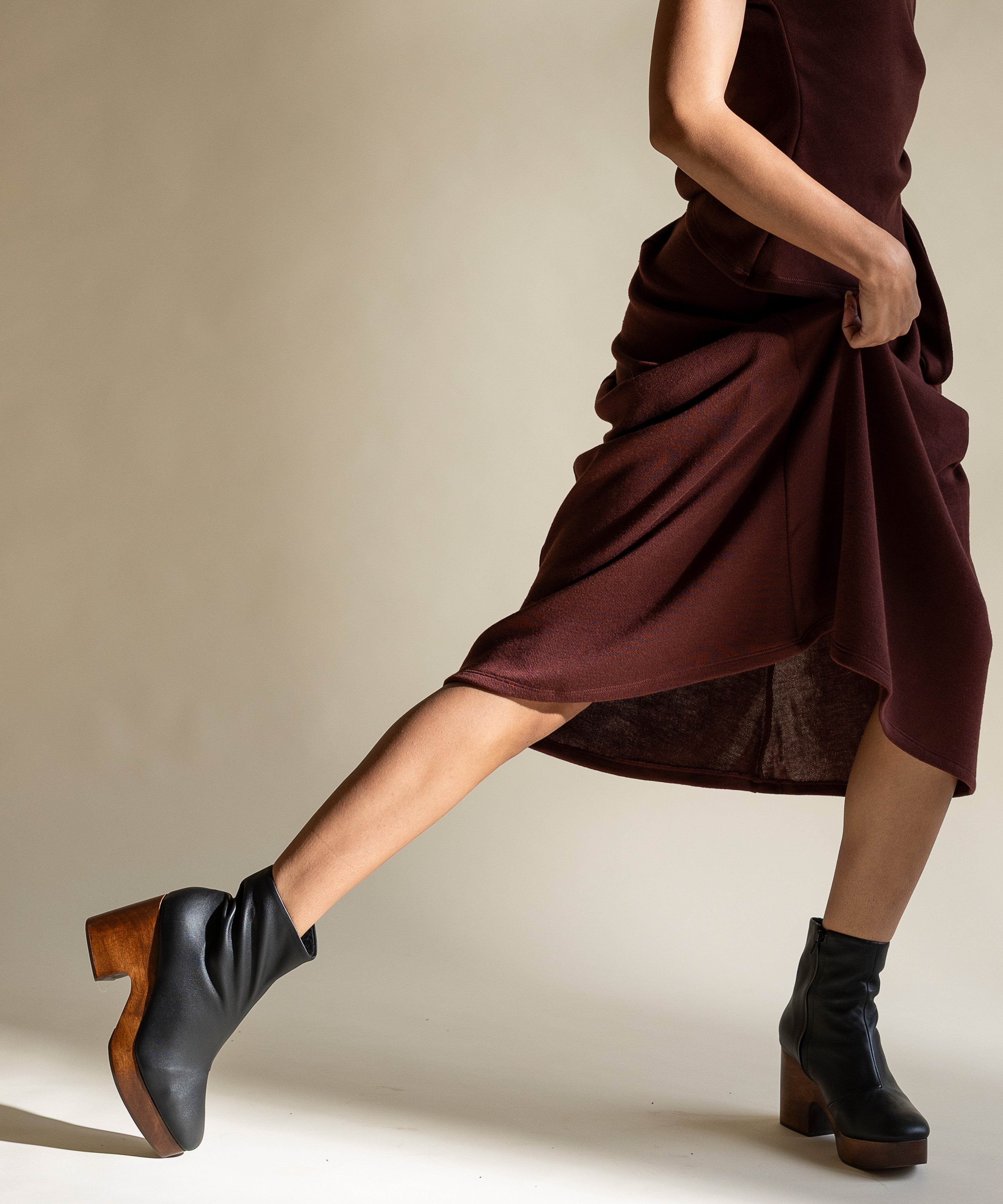 Black leather platform clog boot on woman in dress