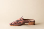 Snake print slip-on shoe with wooden sole on a beige background