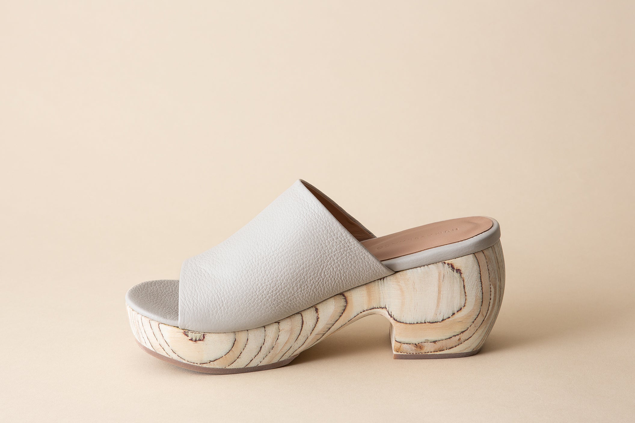 Off-white clog sandals on a beige background