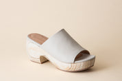 Off-white clog sandals on a beige background