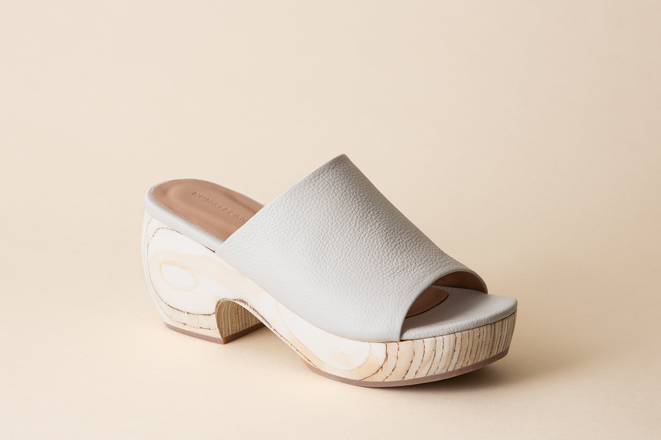 Off-white clog sandals on a beige background