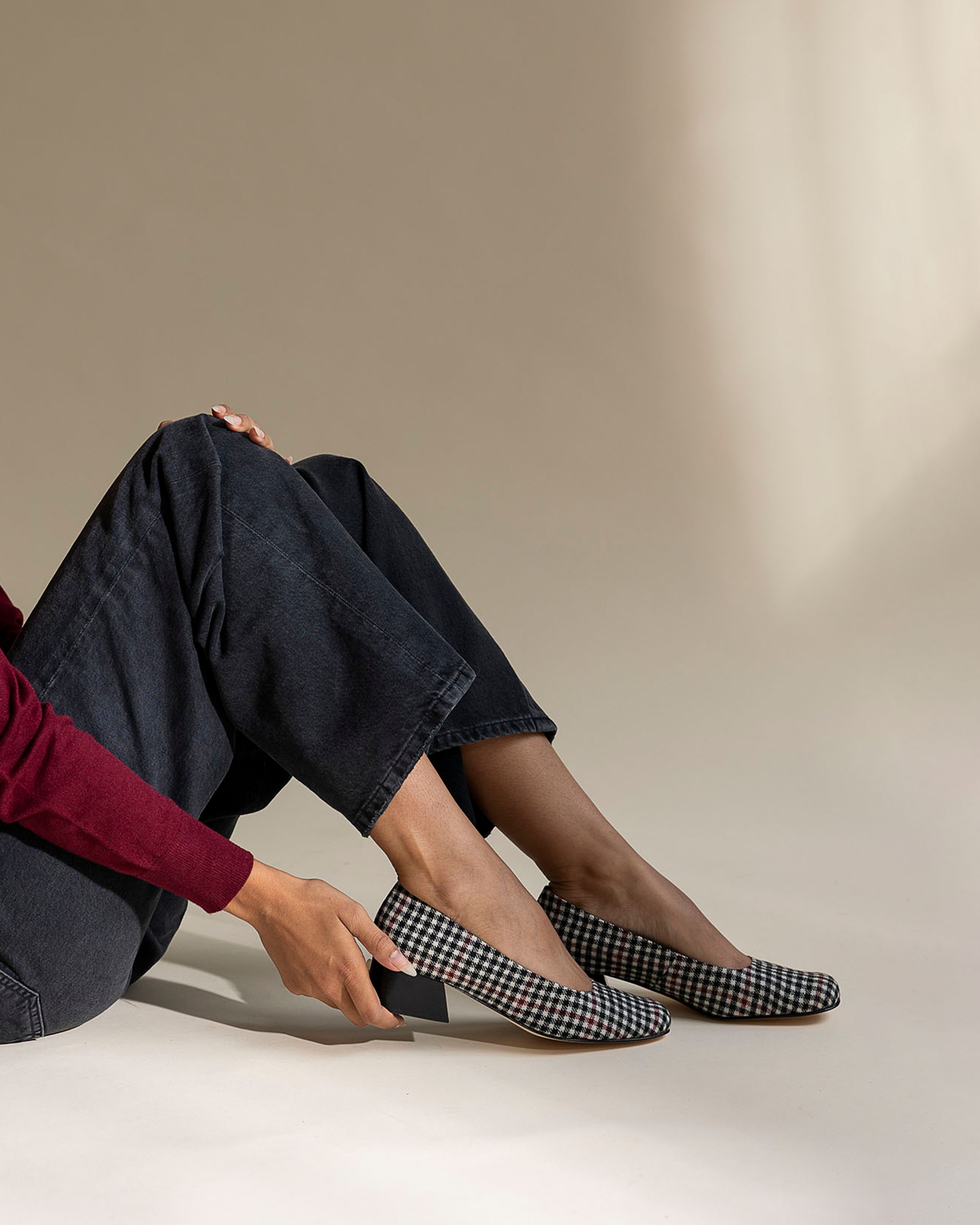 Person wearing black and white plaid shoes with a neutral background