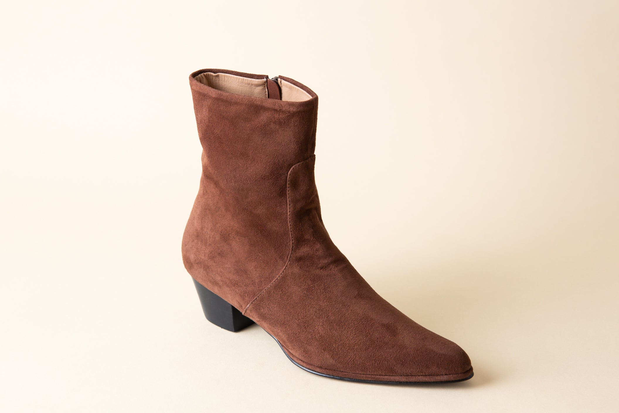 Brown suede ankle boot on a beige background
