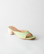 Green sandal with a wooden heel on a light gray background