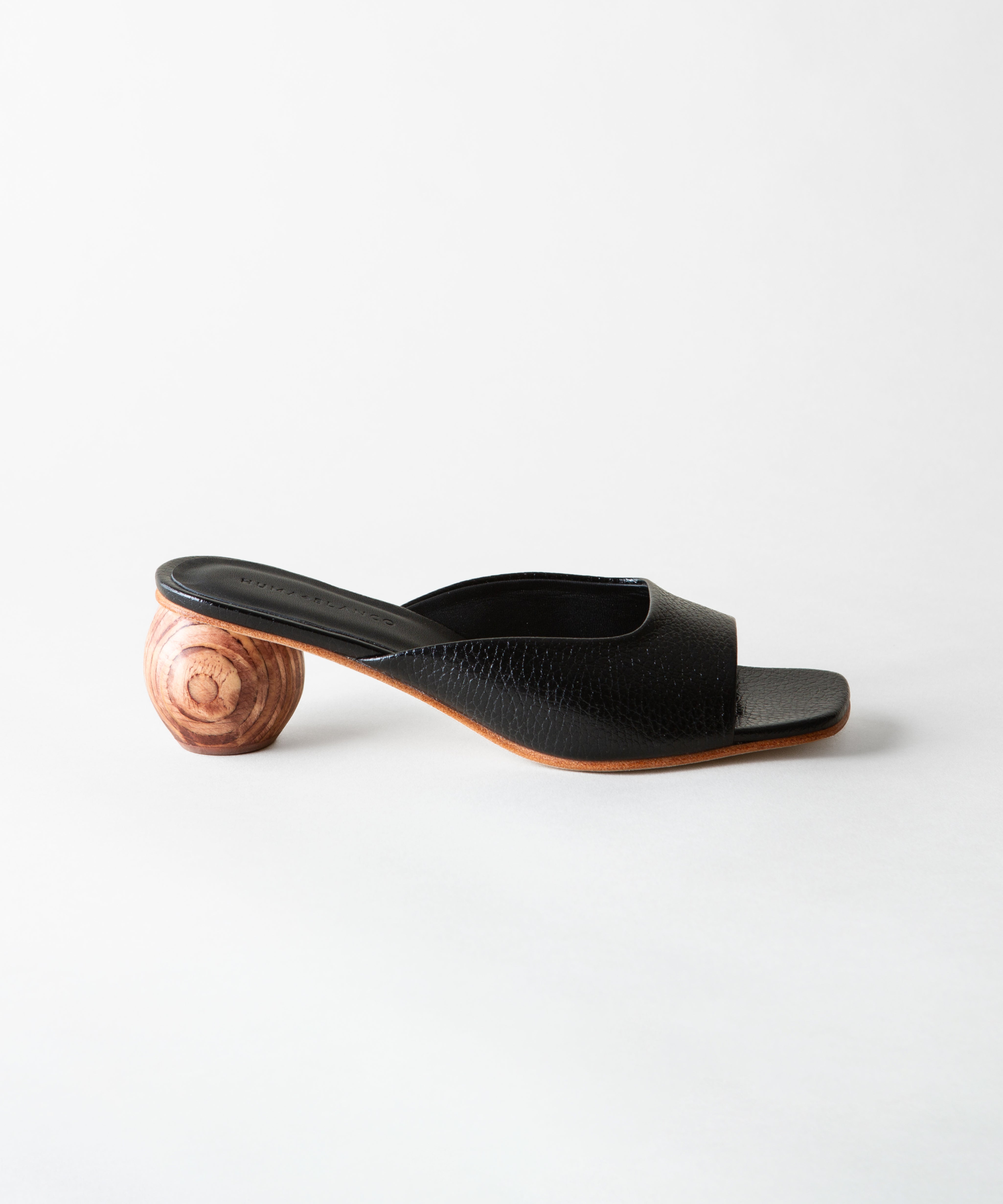 Black open-toe sandal with wooden heel on a white background
