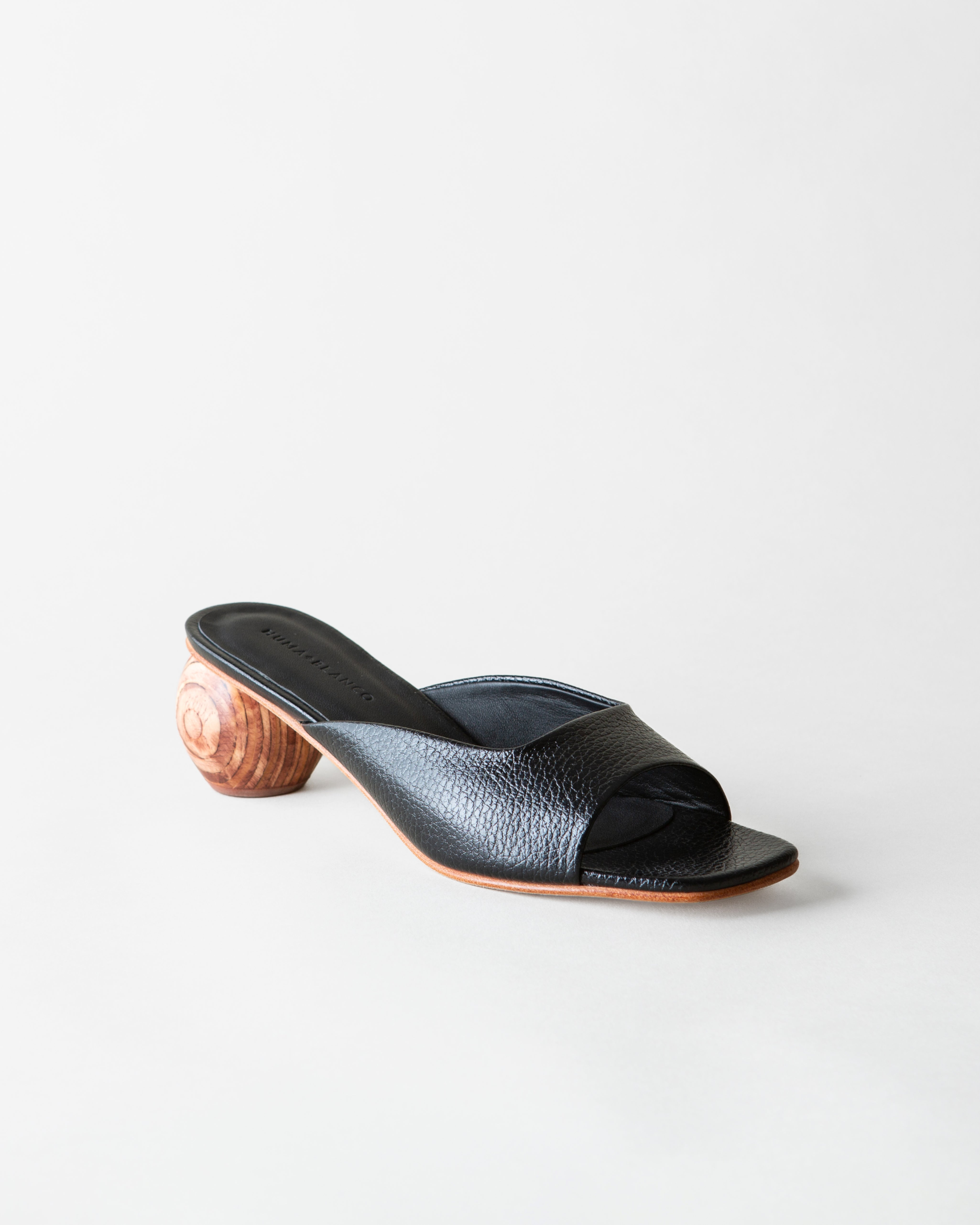 Black sandal with wooden heel on a white background