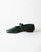 A single dark green snakeskin-patterned flat shoe with a Mary Jane strap, shown in profile against a plain white background.