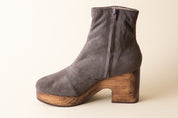 Gray suede ankle boot with wooden heel on a beige background