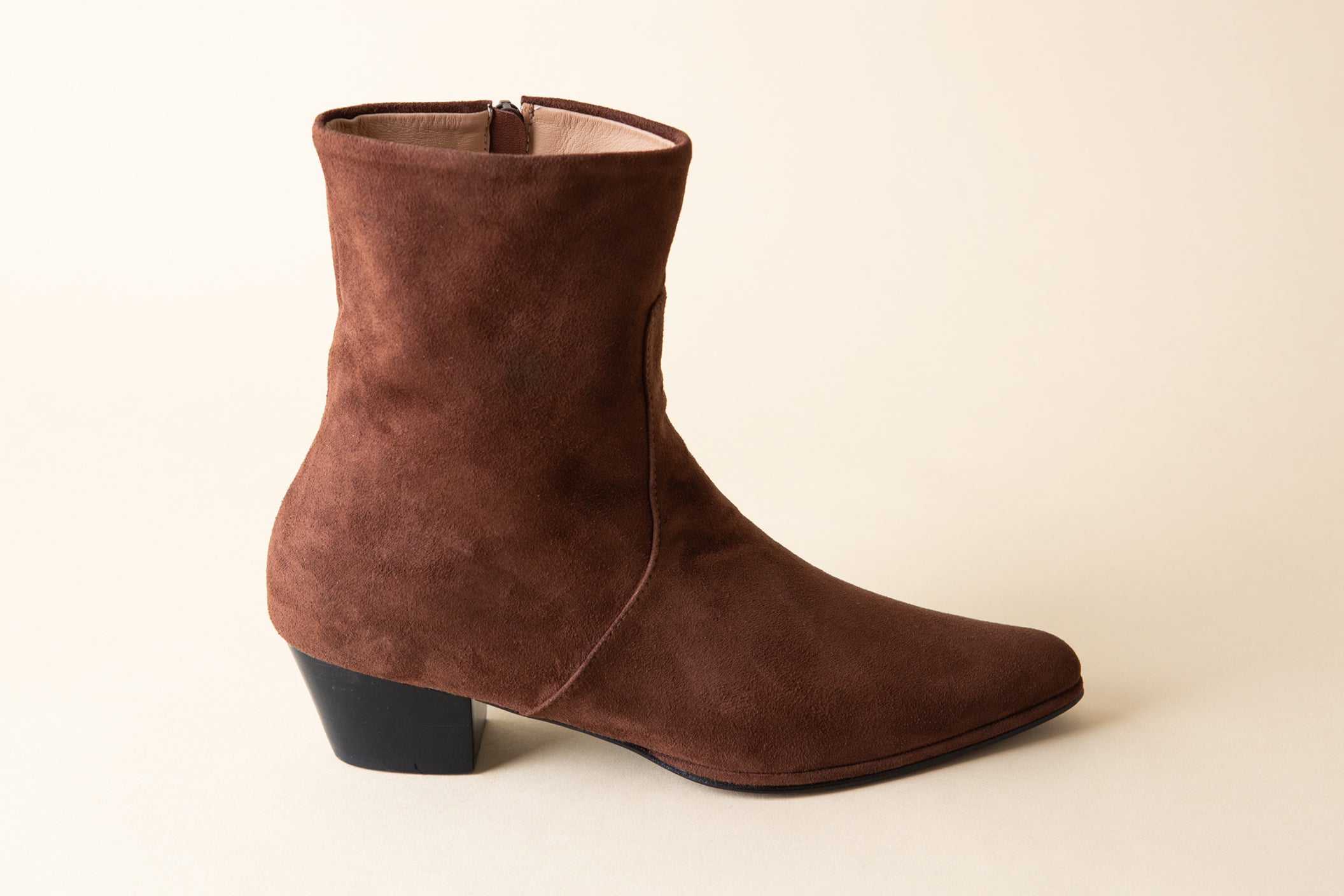 Brown suede ankle boot on a beige background